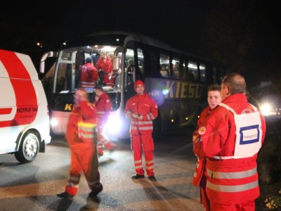 Rakouští záchranáři, v pozadí autobus přistavený Hornorakouským červeným křížem